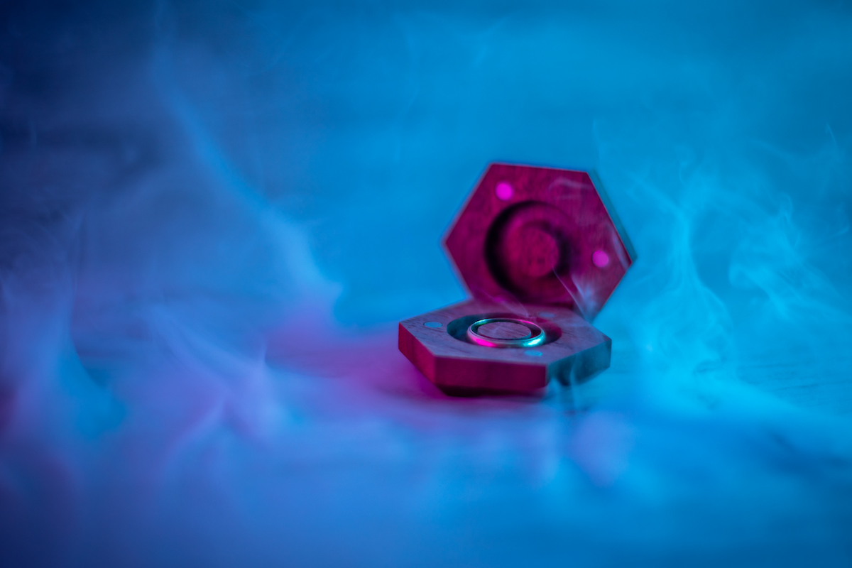 A ring inside of a wooden ring case on a blue, misty background