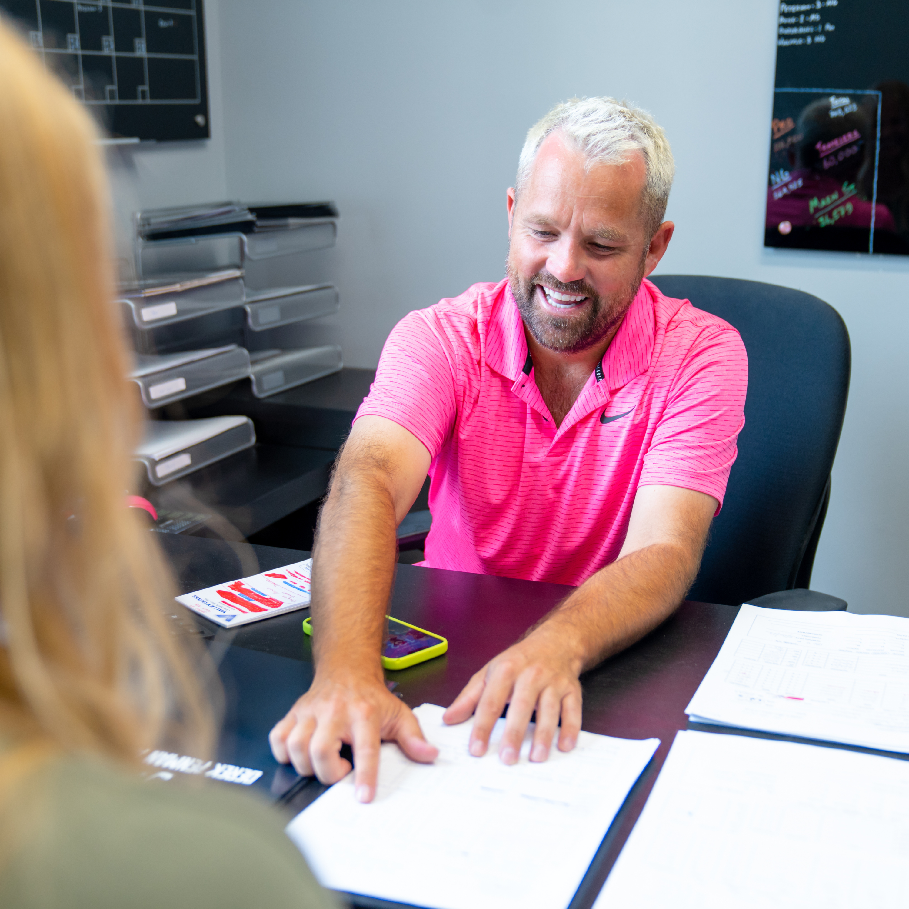 Image of an insurance agent pointing to something on a paper to his client