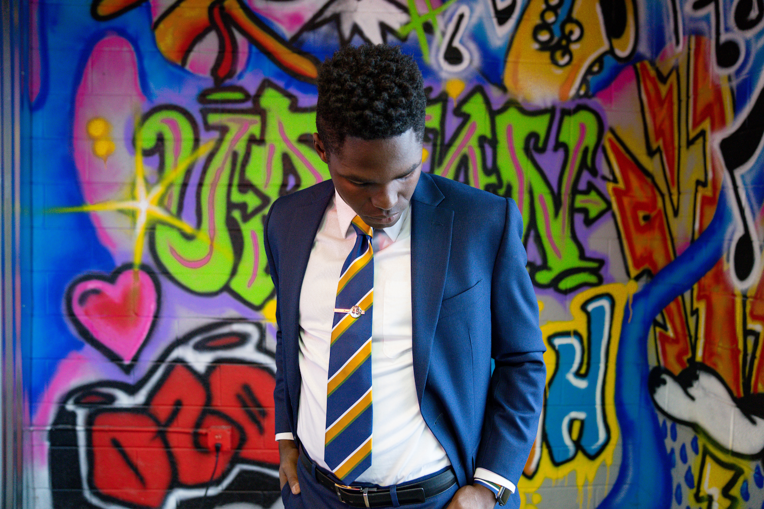 A man in a suit on modeling in front of a graffiti wall