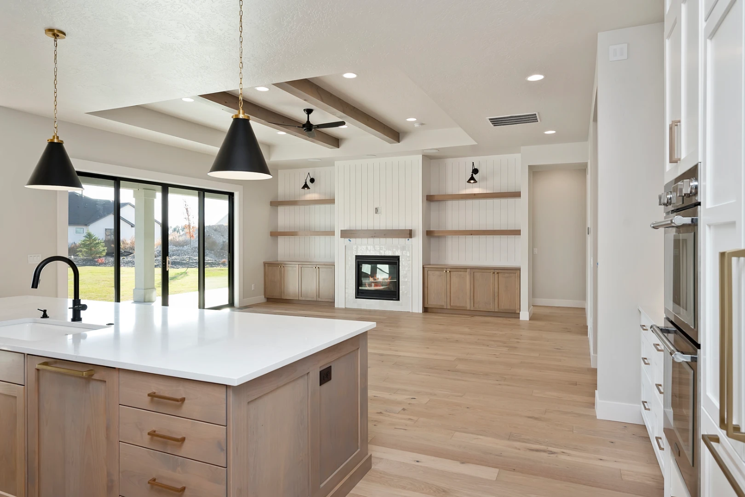A photo of a large open room with brown floors and ceiling beams
